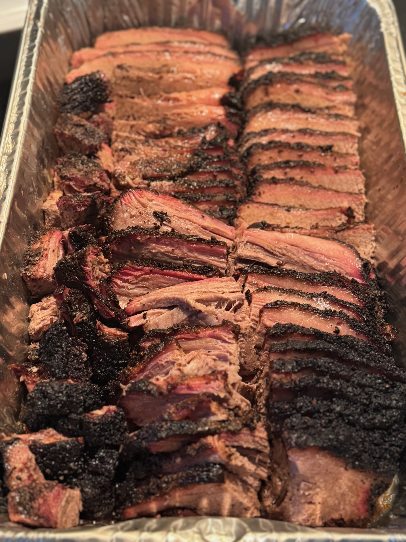 Sliced smoked brisket in a catering pan